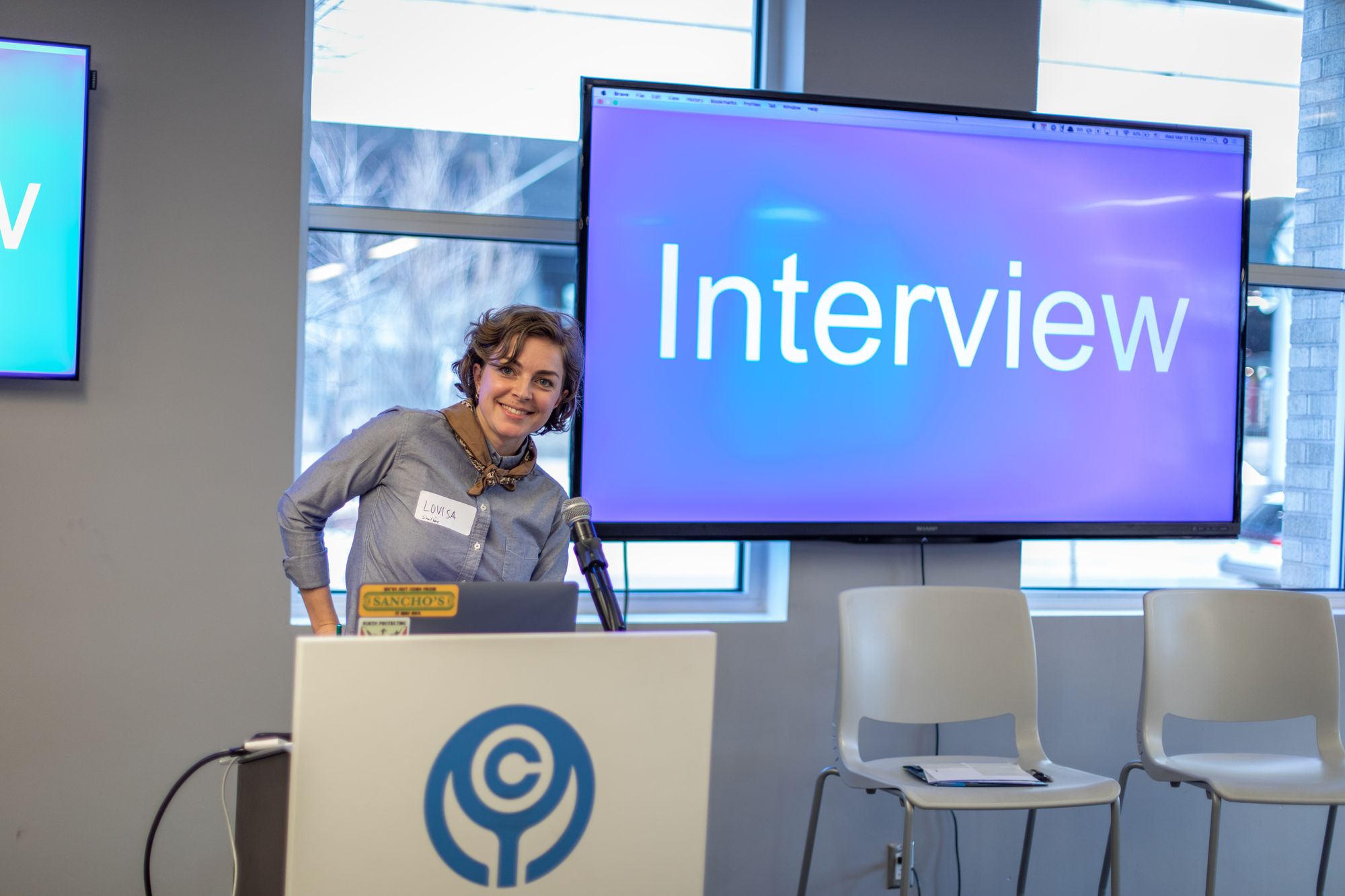 Woman in front of a screen that reads "Interview"